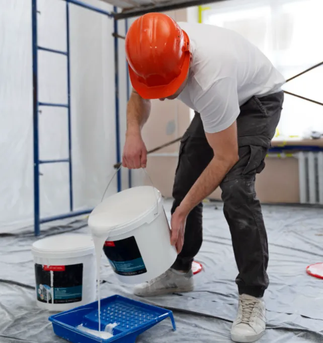 Artisan RM préparant la peinture sur un chantier protégé