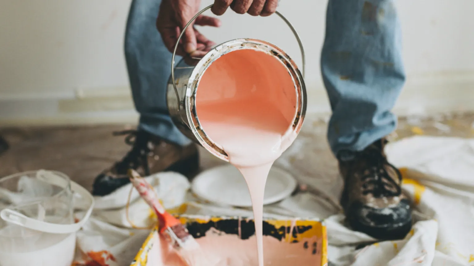 Artisan peintre RM versant de la peinture sur un chantier à Lunel-Viel