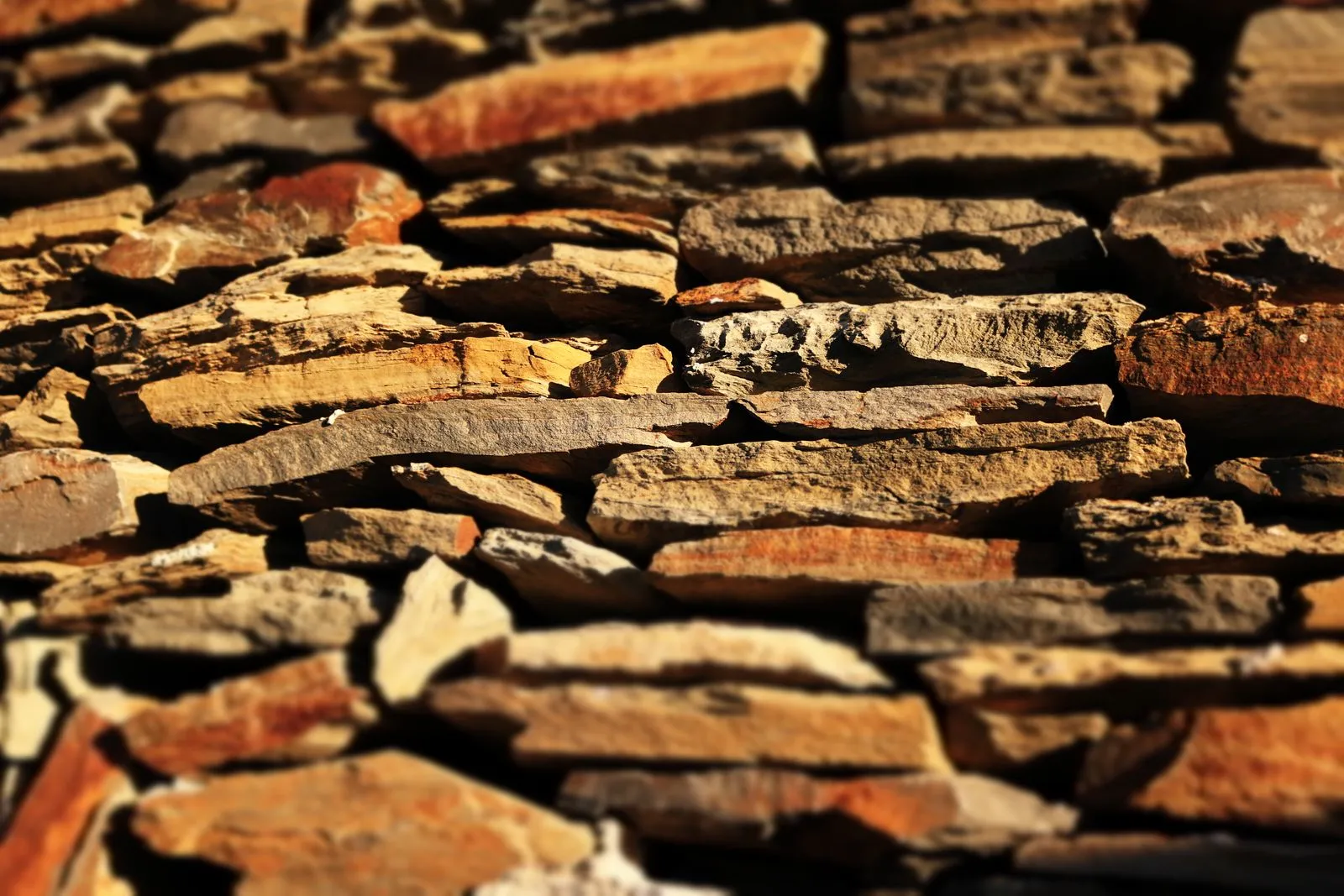 Mur en pierre sèche dorée, appareillage régulier et soigné